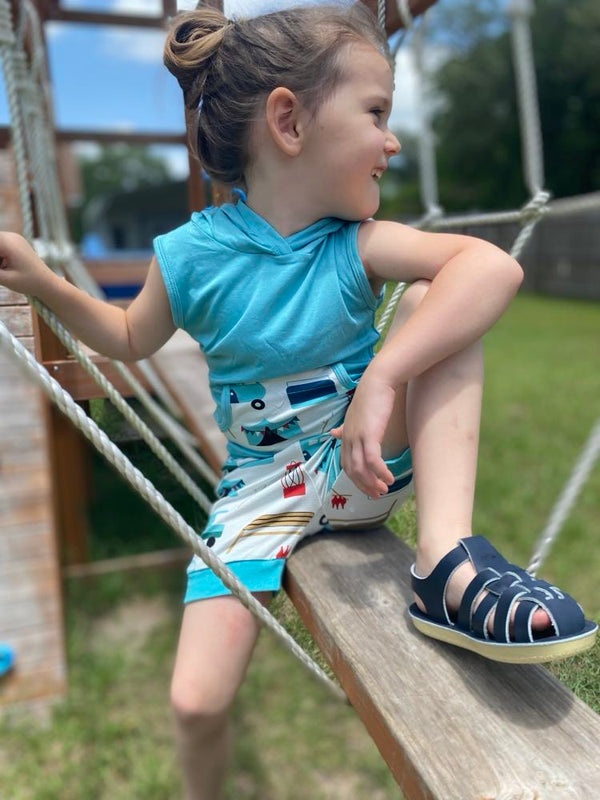 Child in sleeveless hoodie and shorts with camper on them