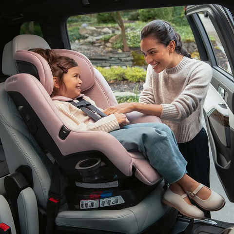 mom buckling in child in pink carseat