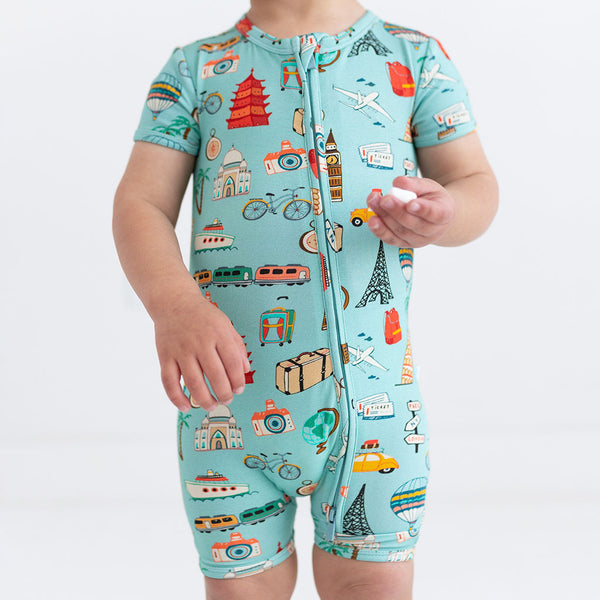 Close up Short Sleeve short length zippered romper in aqua with iconic structures, buildings, and modes of transportation printed all over