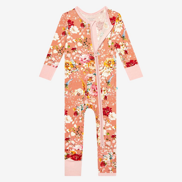 one piece pj Print is orange, red, yellow and white floral on a peachy background.