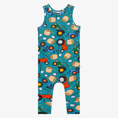 Racerback long pant romper. Pattern of cartoonish red and green tractors, bails of hay and farm tools are on a blue background.