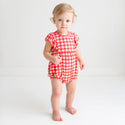 Toddler in a bubble romper. Pattern is a red and white country checkered.
