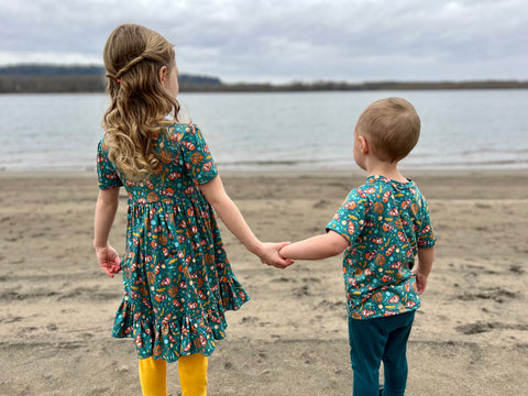 Little girl and boy holding hands on the beach