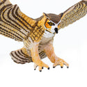 Close up of the Great Horned Owl with wings spread open. His coloring is a beautiful yellow and brown strip with white underbelly and markings on the face