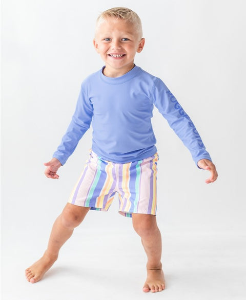 Blonde boy wearing a Periwinkle Blue long sleeve rash guard with the Ruggedbutts logo on the sleeve.