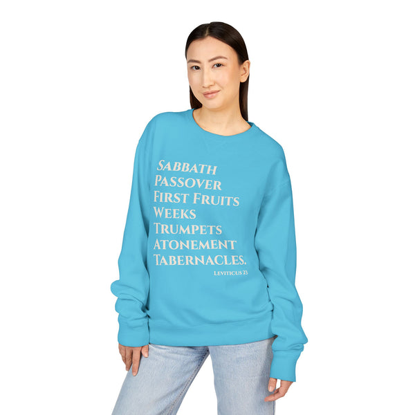 Person wearing a blue sweatshirt with religious text on a white background
