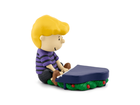 Toy figure of a boy playing a keyboard on a white background