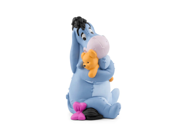 Eeyore holding a small bear plush toy on a white background