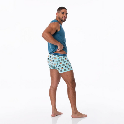 Man standing in These boxers have a solid deep blue sea waist band. The Boxers have a solid aqua background with Vantage Vans with a peace symbol on the front of each one. The colors of the vans are in straight lines across and down the boxers in the following colors; Blue, Orange, Blue, Green, etc.