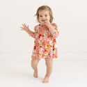 Orange, white and red floral dress with peachy pink bloomers on toddler.
