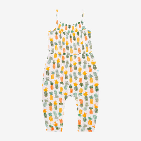 Jumpsuit has a white background with Light Green, Dark Green, Yellow, and Orange Pineapples all over it.