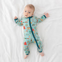 Baby wearing One Piece PJ with aqua canvas and iconic structures, buildings, and modes of transportation with a deep teal trim and cuffs