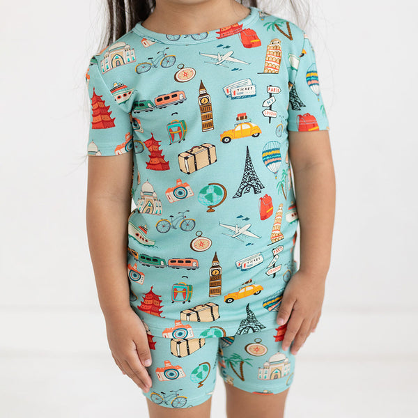 Close up of girl wearing Two piece PJ set in aqua with iconic structures, buildings and modes of transportation all over