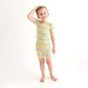 Boy wearing pajamas. These pajamas has a white background with horizontal stripes. Aqua, Mustard, Sage Green, and Coral
