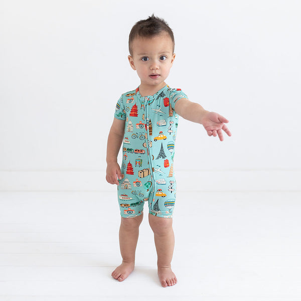Boy wearing Short Sleeve short length zippered romper in aqua with iconic structures, buildings, and modes of transportation printed all over