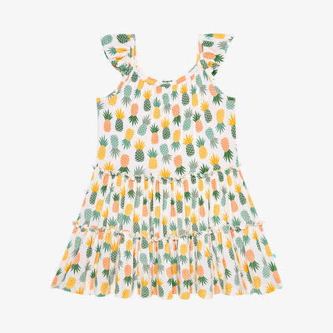 Flutter Sleeve Tiered dress has a white background with Pineapple print. Light Green, Dark green, Orange, and Yellow Pineapples are repeated all over with a white background