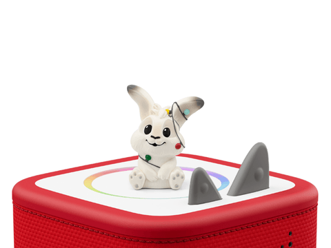 White rabbit figurine on a red toy box  on a white background