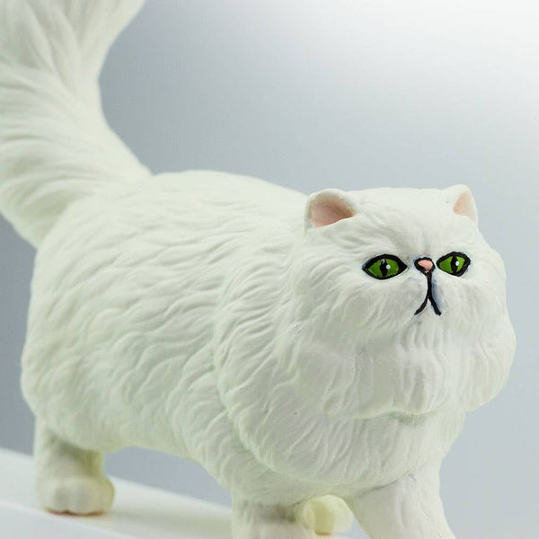 Its coat is white, its ears and nose are peach-colored, and its eyes are green.