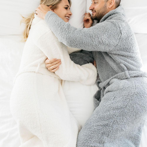 Man and woman lying down wearing robes