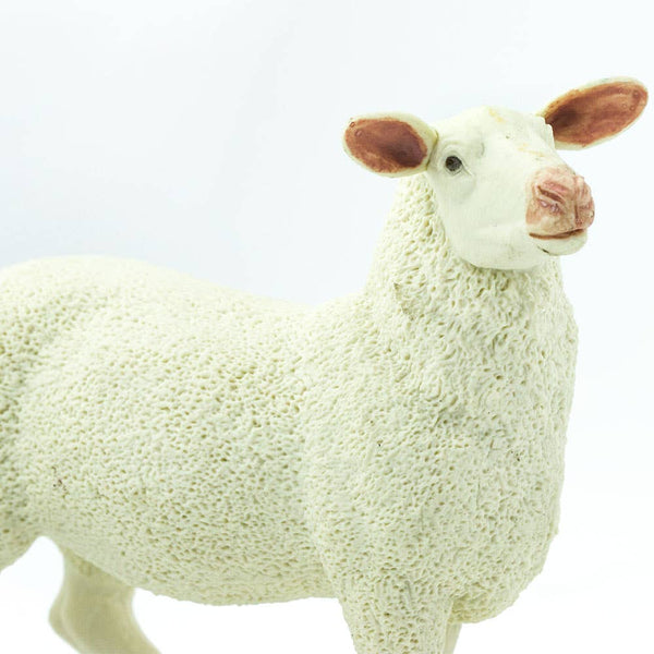 Primarily white, this 3-inch-long ewe features additional color on the hooves and about the face,