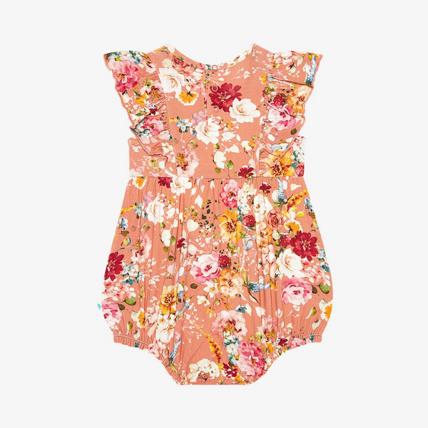 The back of a flutter sleeve romper. Print is orange, red, yellow and white floral on a peachy background.