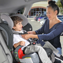 woman buckling in her child into the grow with you carseat