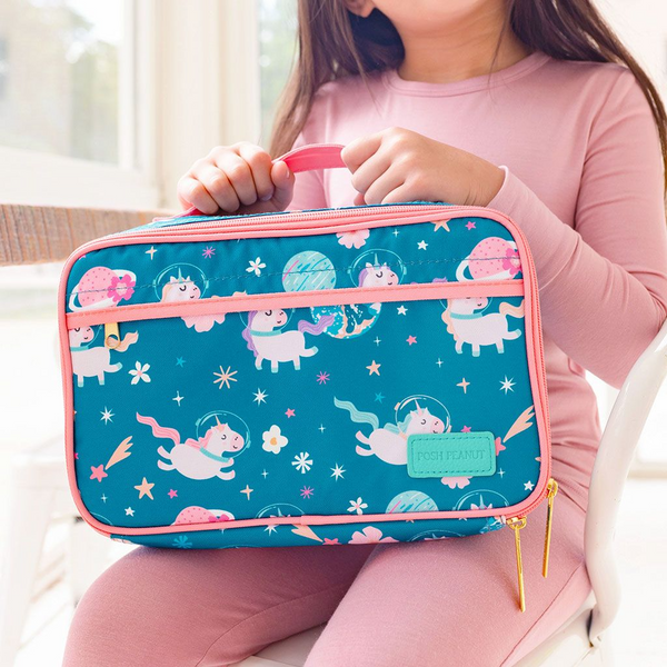 Girl holding Lunch bag with pink trim, gold hardware. Blue background with Unicorns flying through space with a clear glass space helmet