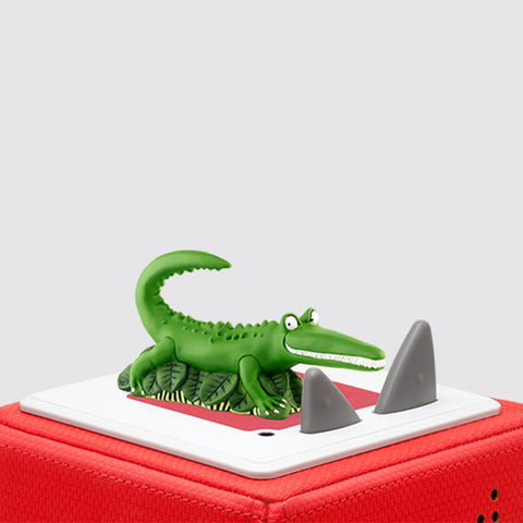 Tonies Enormous Crocodile character is a green crocodile with an big white toothed smile sitting on a red toniebox.