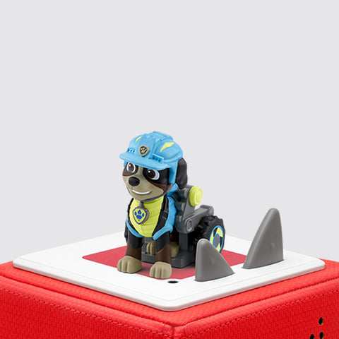 Tonies Paw Patrol Rex character is a brown dog with a blue and yellow suit sitting on a red TOniebox.