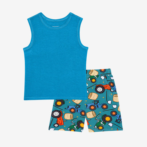 Tank top is solid blue and shorts are a pattern of cartoonish red and green tractors, bails of hay and farm tools are on a blue background. 