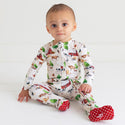 Toddler sitting in a zippered footie. Country farm print on a cream background. 