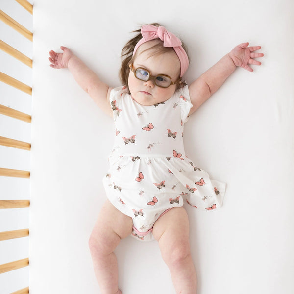LIttle girl in bodysuit with twirl skirt. White solid background with butteflies print